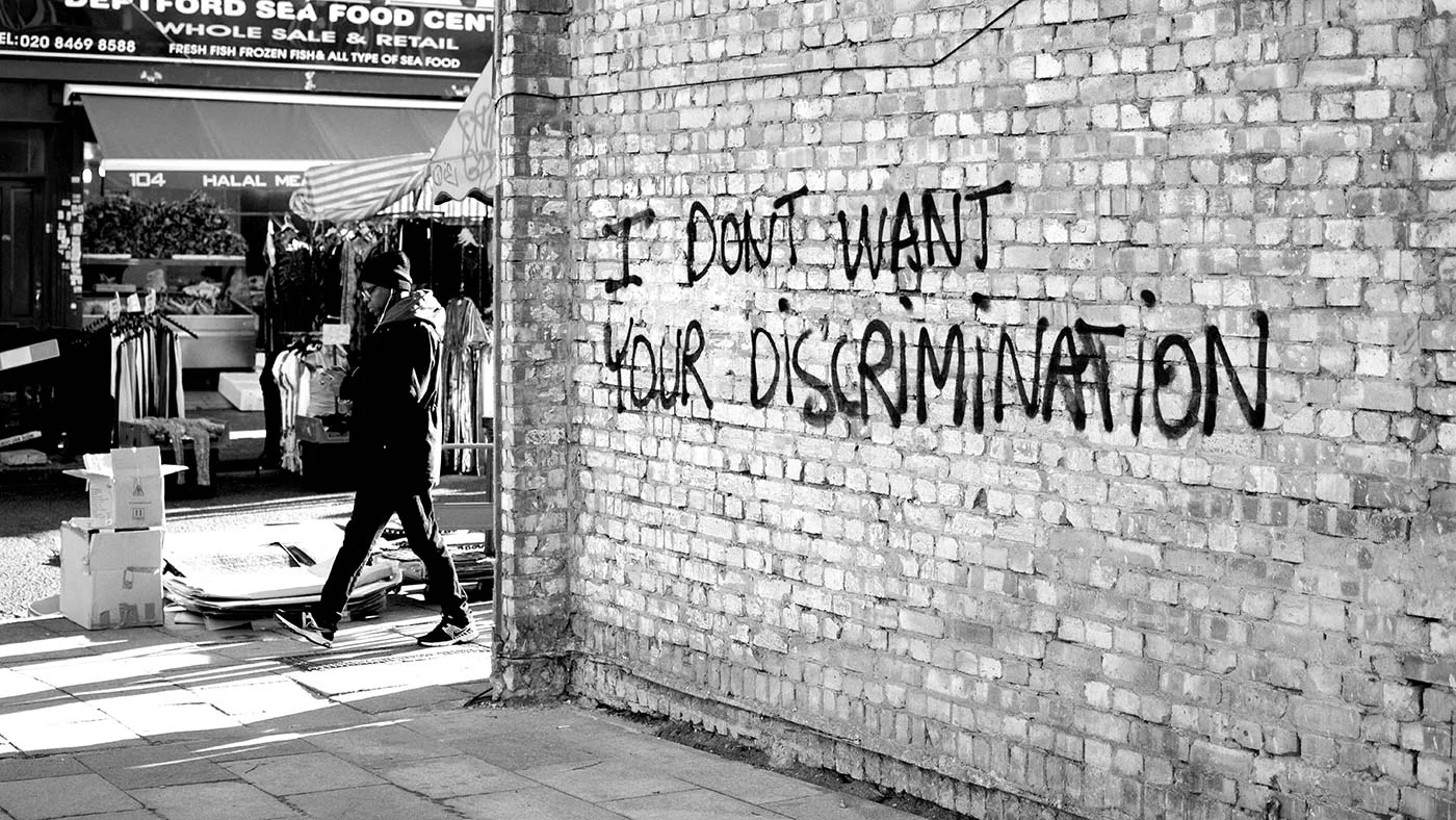 Vägg där något sprejat budskapet 'I don´t want your discrimination'